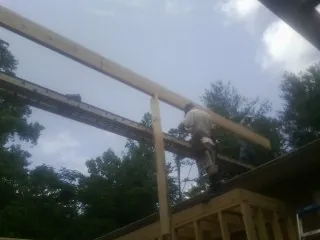 Carpenter setting a ridge beam over a new addition frame — Ice Dam Removal by Roofing Brothers in Devers