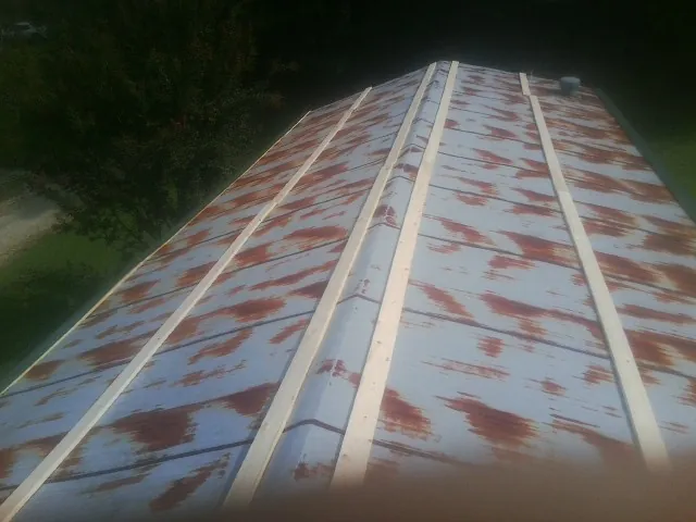 Rusted metal roof panels with new wood purlins before replacement — Storm Damage Roof Repair in Devers by Roofing Brothers